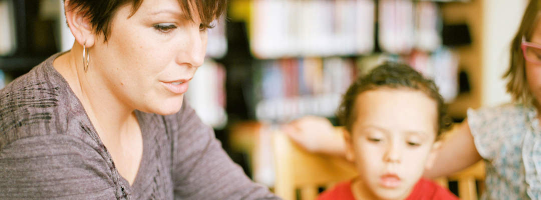 Woman in gray long sleeve shirt sitting beside boy in orange crew neck shirt Woman in gray long sleeve shirt sitting beside boy in orange crew neck shirt